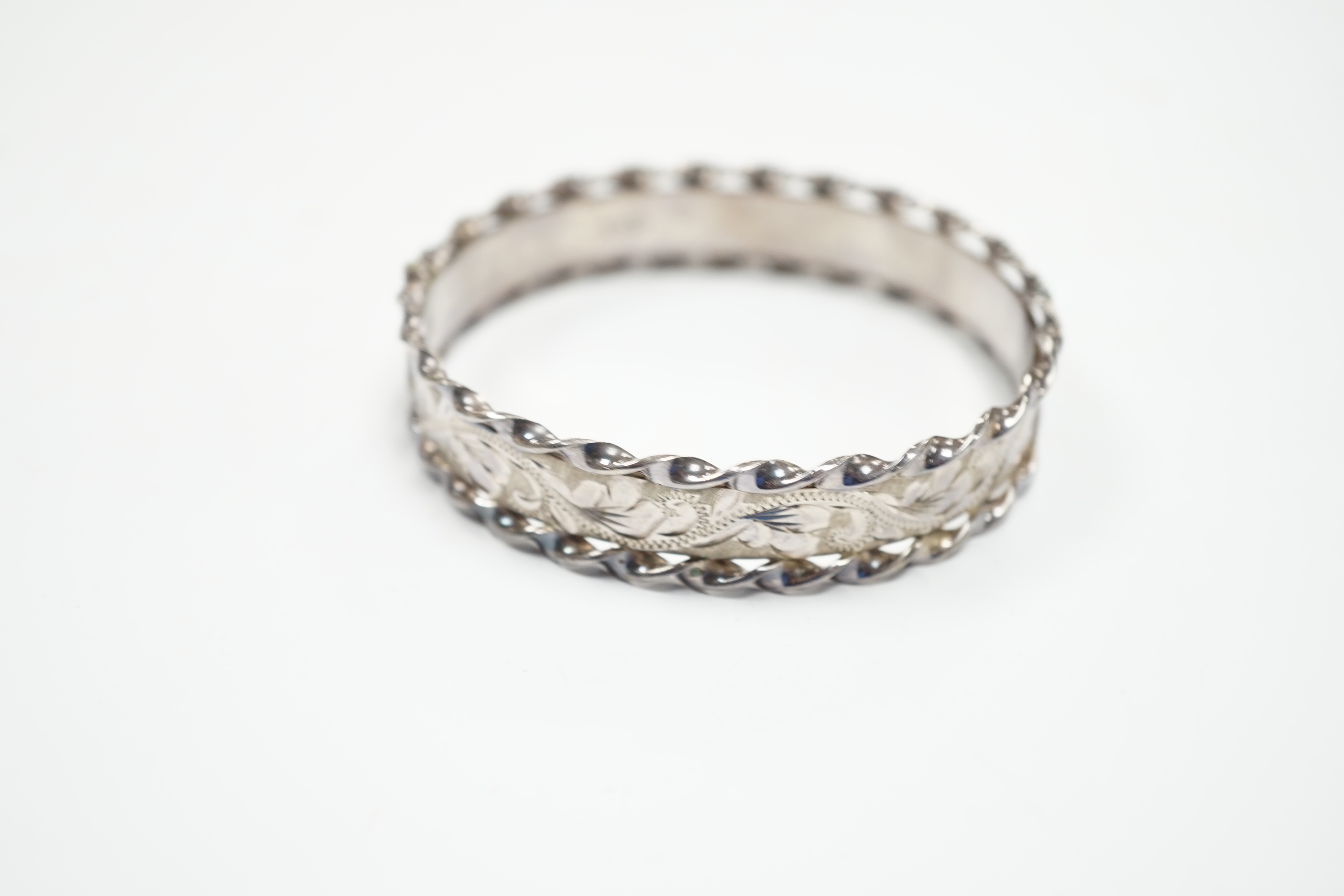 An Elizabeth II bright cut engraved silver hinged bangle, with spiral borders, Birmingham, 1978.